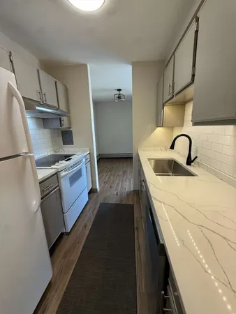 a kitchen with kitchen island granite countertop a sink appliances and cabinets