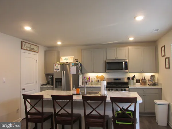 a kitchen with a dining table chairs and refrigerator