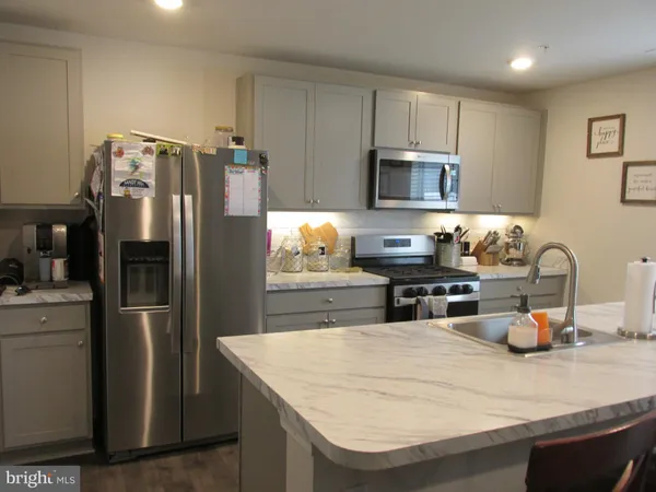 a kitchen with stainless steel appliances granite countertop a refrigerator and a stove