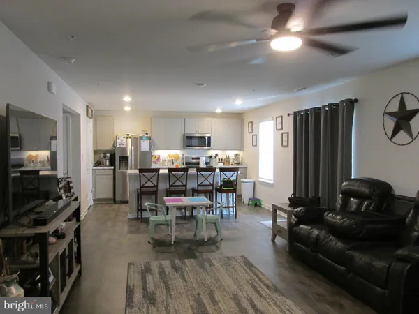 a living room with lots of furniture and kitchen view