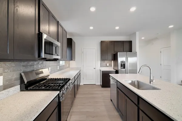 a kitchen with stainless steel appliances a sink stove and refrigerator