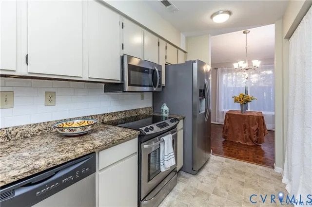 a kitchen with stainless steel appliances granite countertop a stove a refrigerator and a microwave