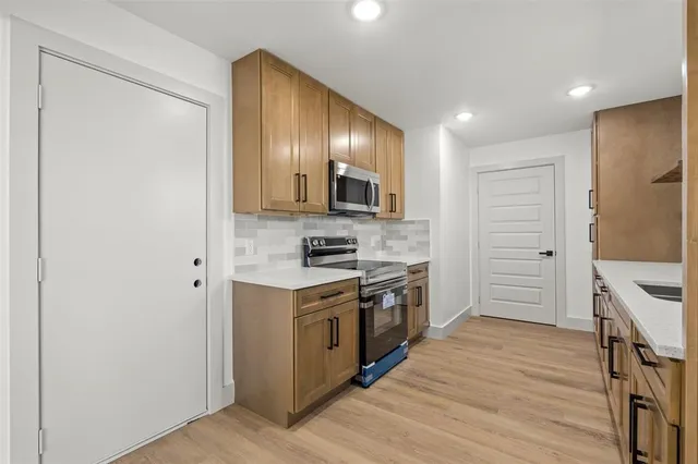 a kitchen with a stove a sink and a refrigerator