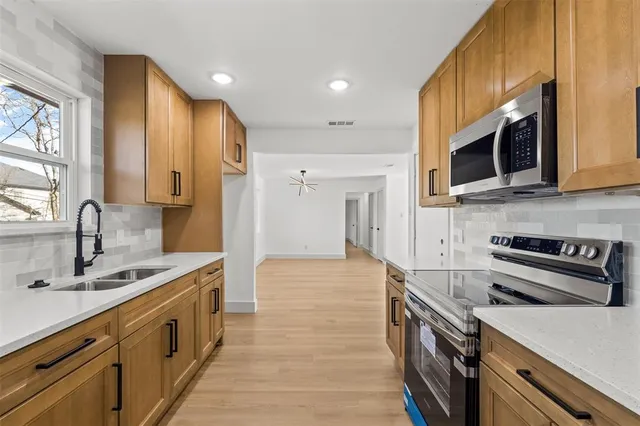 a kitchen with stainless steel appliances a sink stove and cabinets