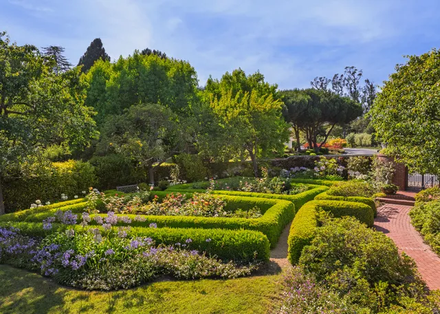 a view of an empty room with wooden floor and a fireplace