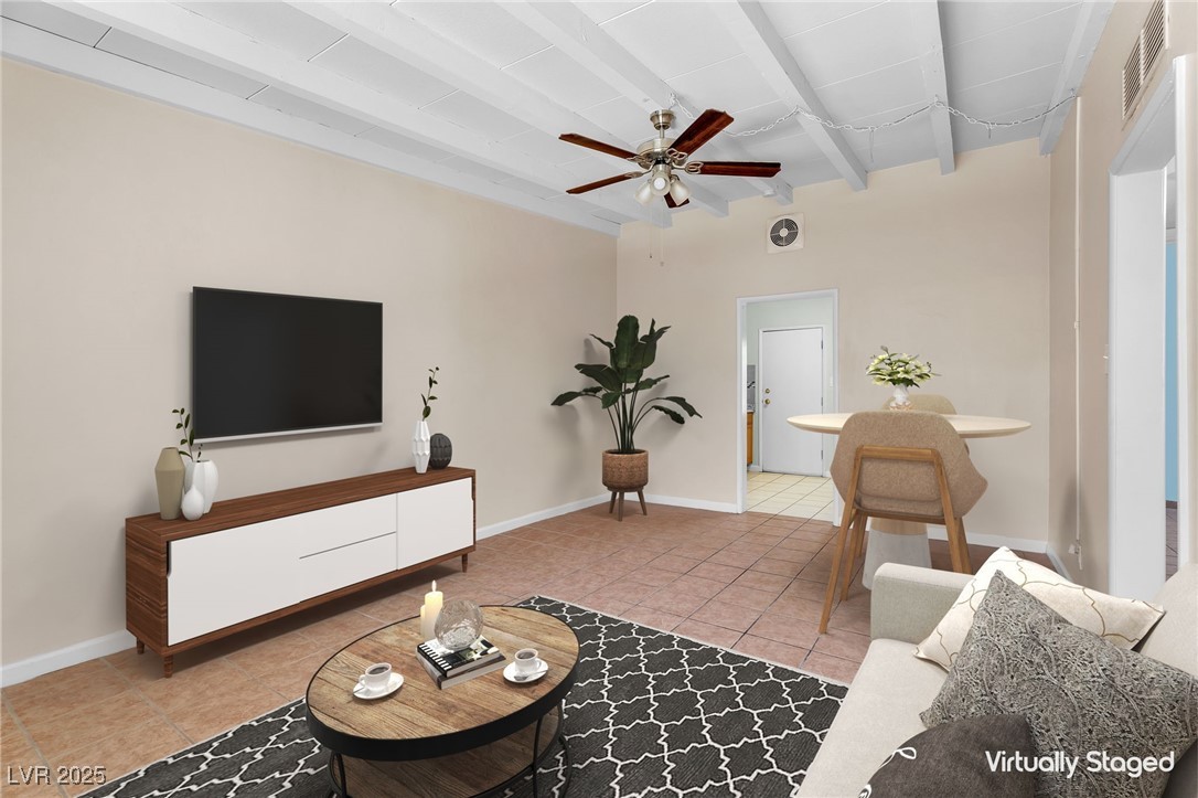 Living room with beam ceiling, light tile patterned flooring, and a ceiling fan
