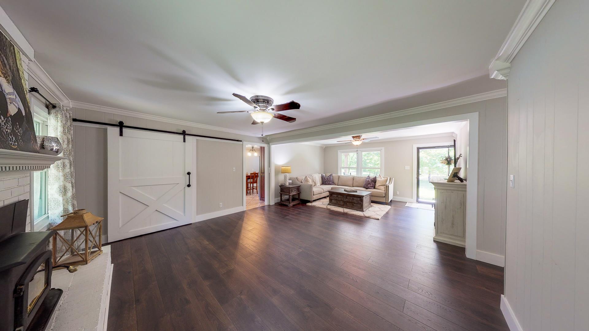 2361 Joe Brown Road Spring Hill, TN 37174 - Photo 7 of 27 a view of a livingroom with wooden floor and a ceiling fan
