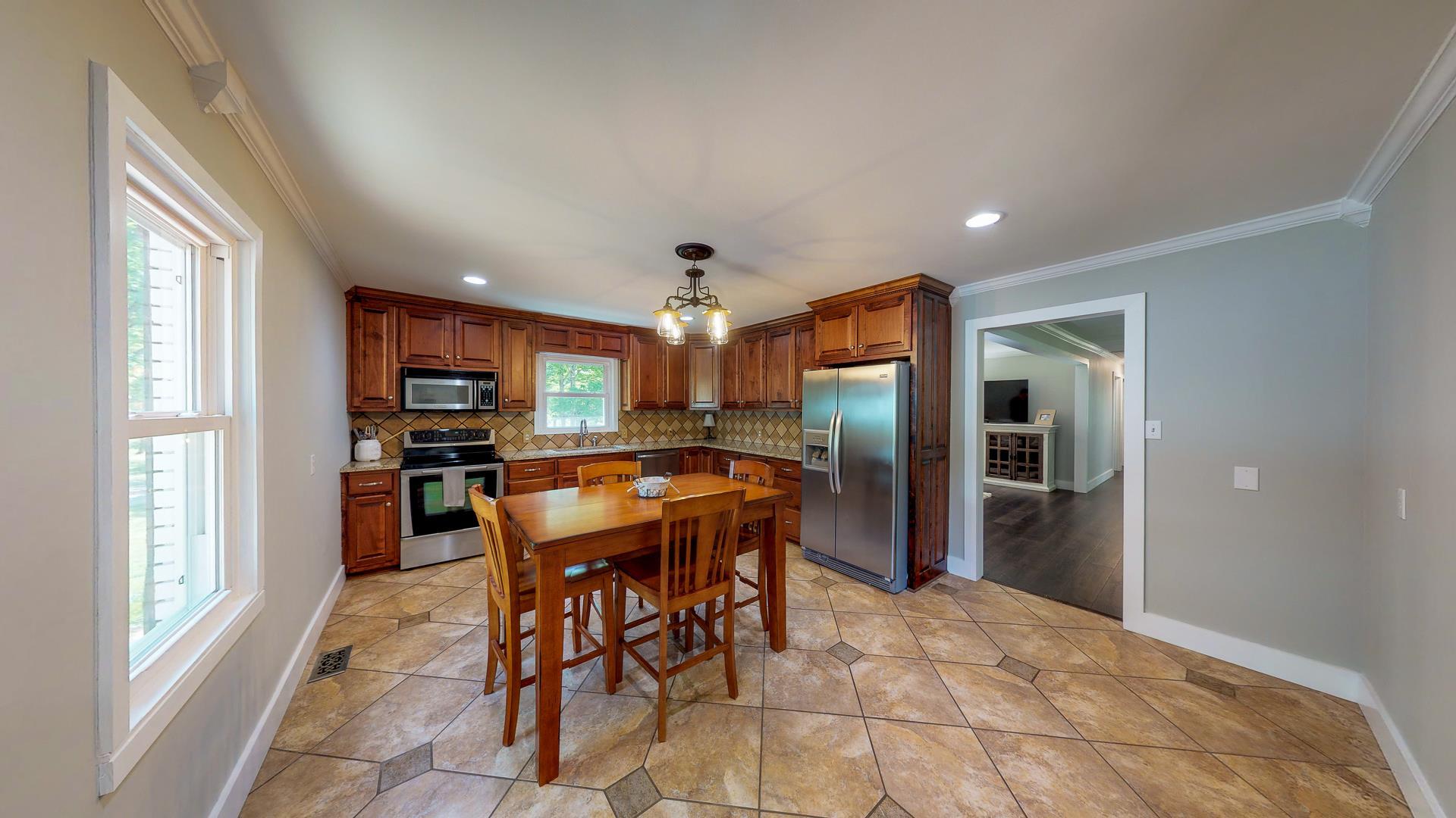 2361 Joe Brown Road Spring Hill, TN 37174 - Photo 10 of 27 a kitchen with stainless steel appliances kitchen island granite countertop a refrigerator and microwave