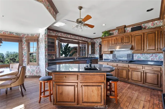 a kitchen with stainless steel appliances granite countertop a sink and wooden cabinets