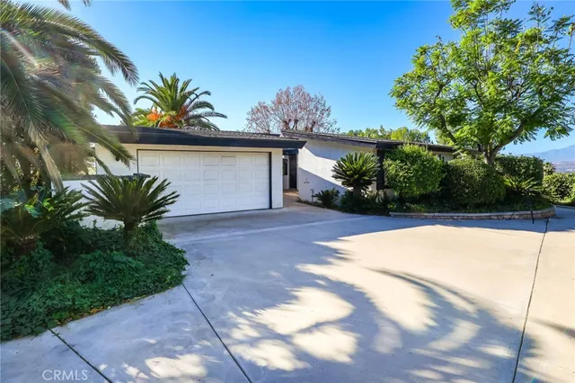 a view of a house with a yard and potted plants