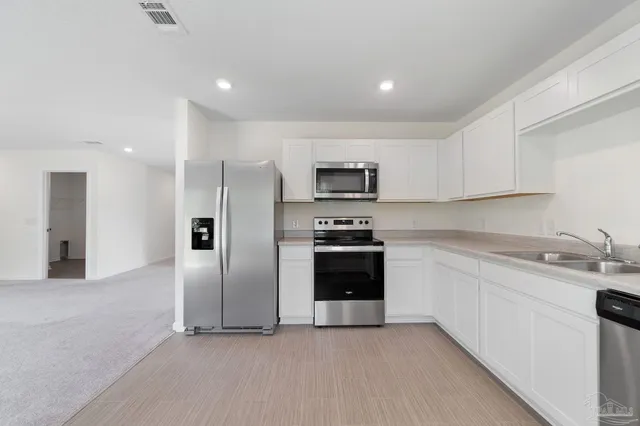 a kitchen with stainless steel appliances granite countertop a refrigerator and a sink