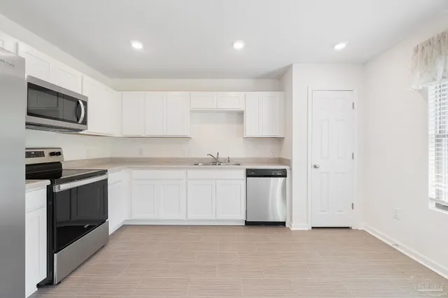 a kitchen with stainless steel appliances granite countertop a refrigerator and a stove top oven