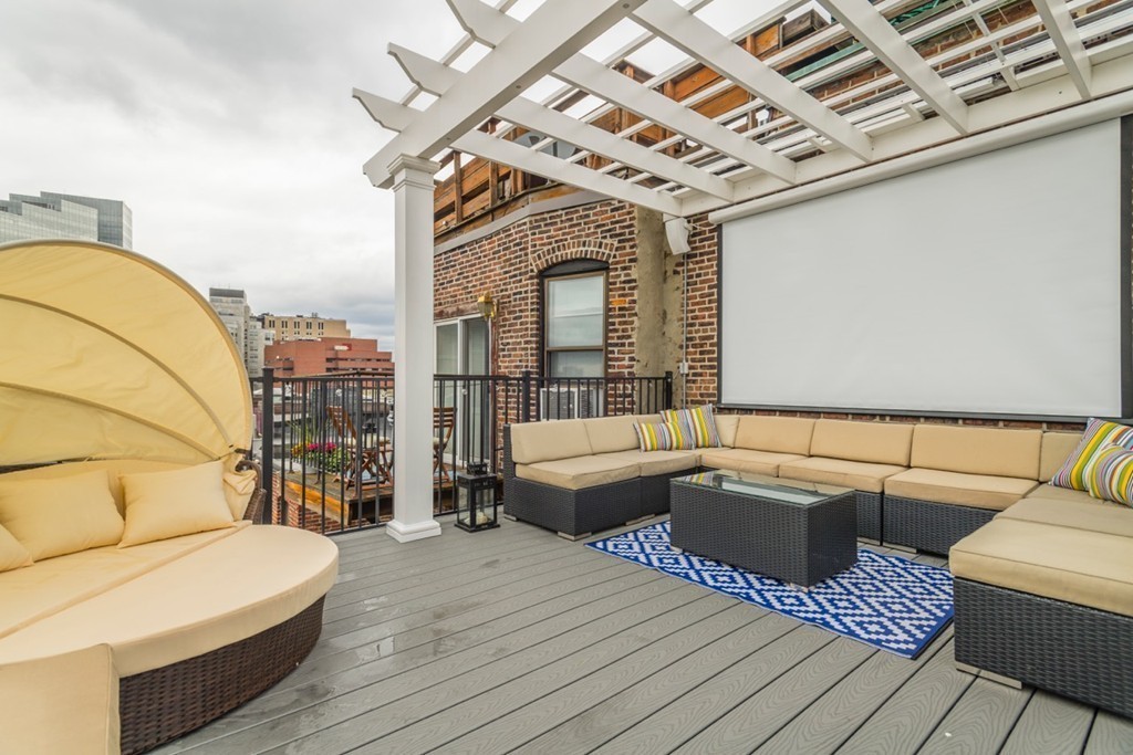 a roof deck with couches and wooden floor