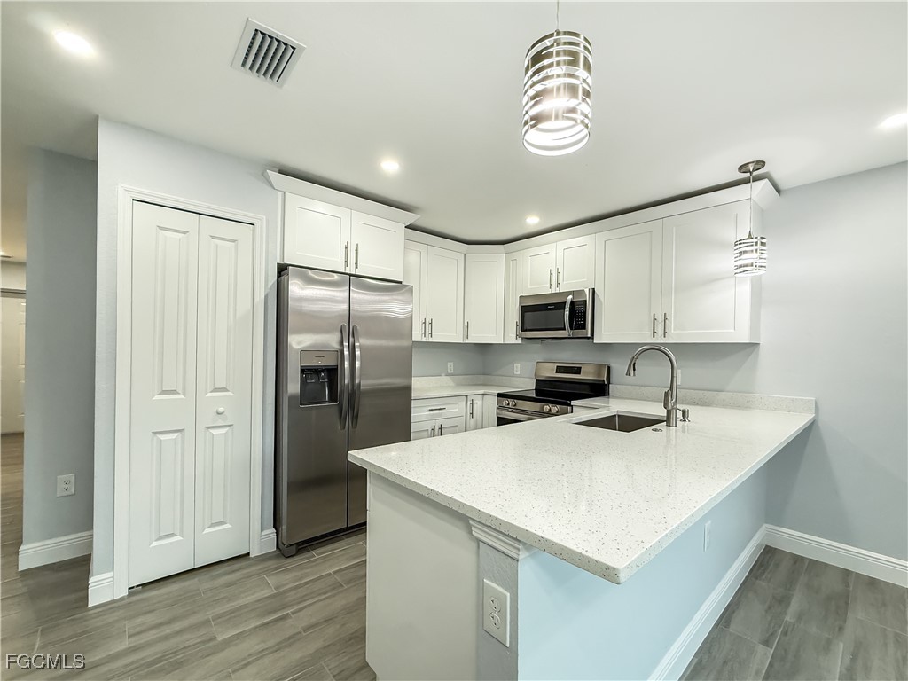 2955 Dunbar Street, Unit A B Fort Myers, FL 33916 - Photo 11 of 19 a kitchen with a refrigerator a sink cabinets and wooden floor