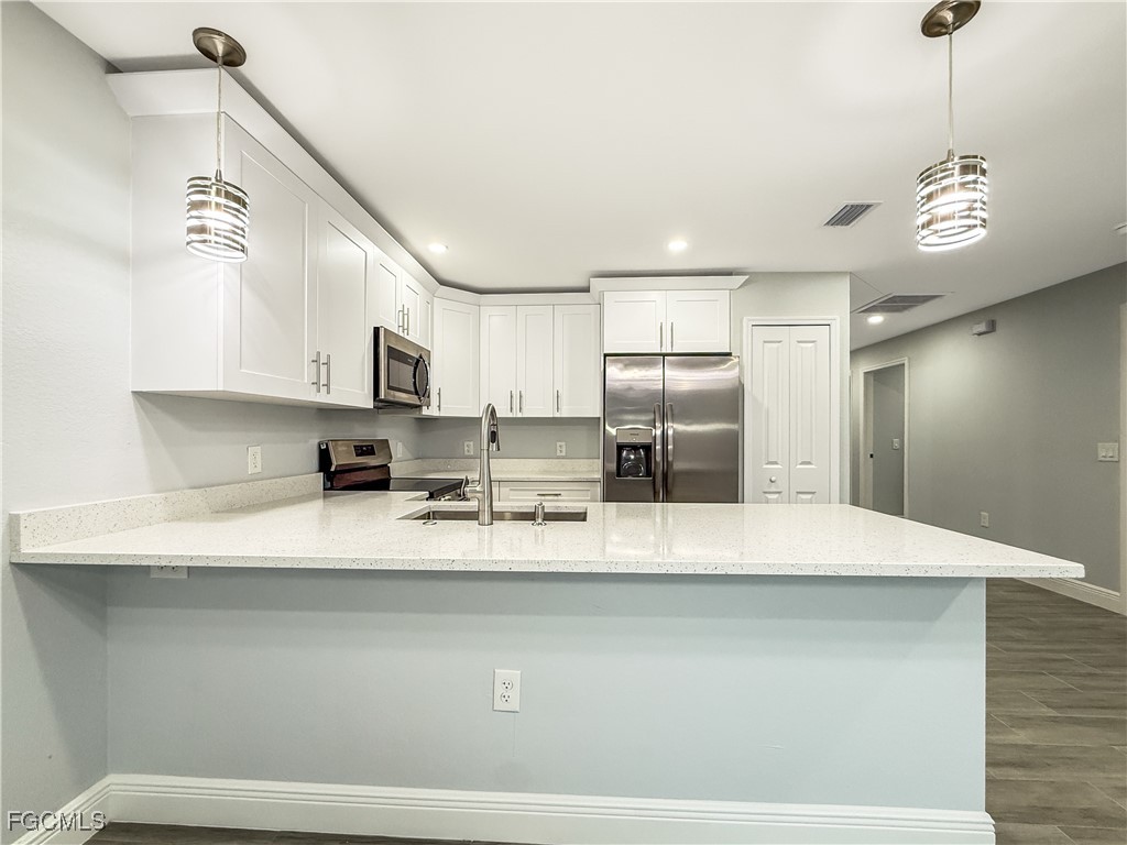 2955 Dunbar Street, Unit A B Fort Myers, FL 33916 - Photo 12 of 19 a large kitchen with stainless steel appliances a large counter top a stove and a refrigerator