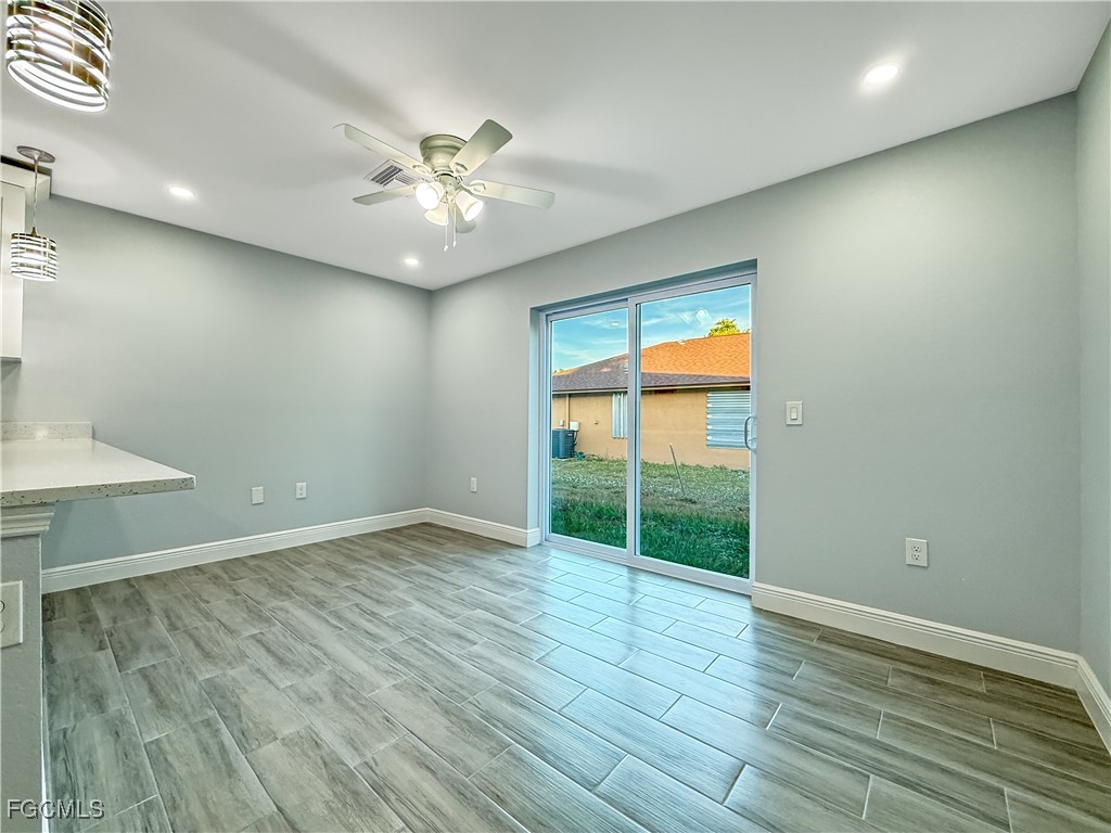 2955 Dunbar Street, Unit A B Fort Myers, FL 33916 - Photo 7 of 19 an empty room with wooden floor fan and windows