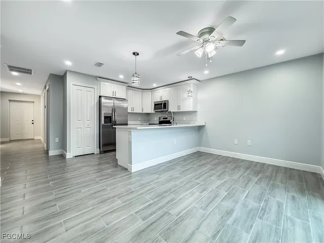 a view of kitchen with cabinets appliances and wooden floor