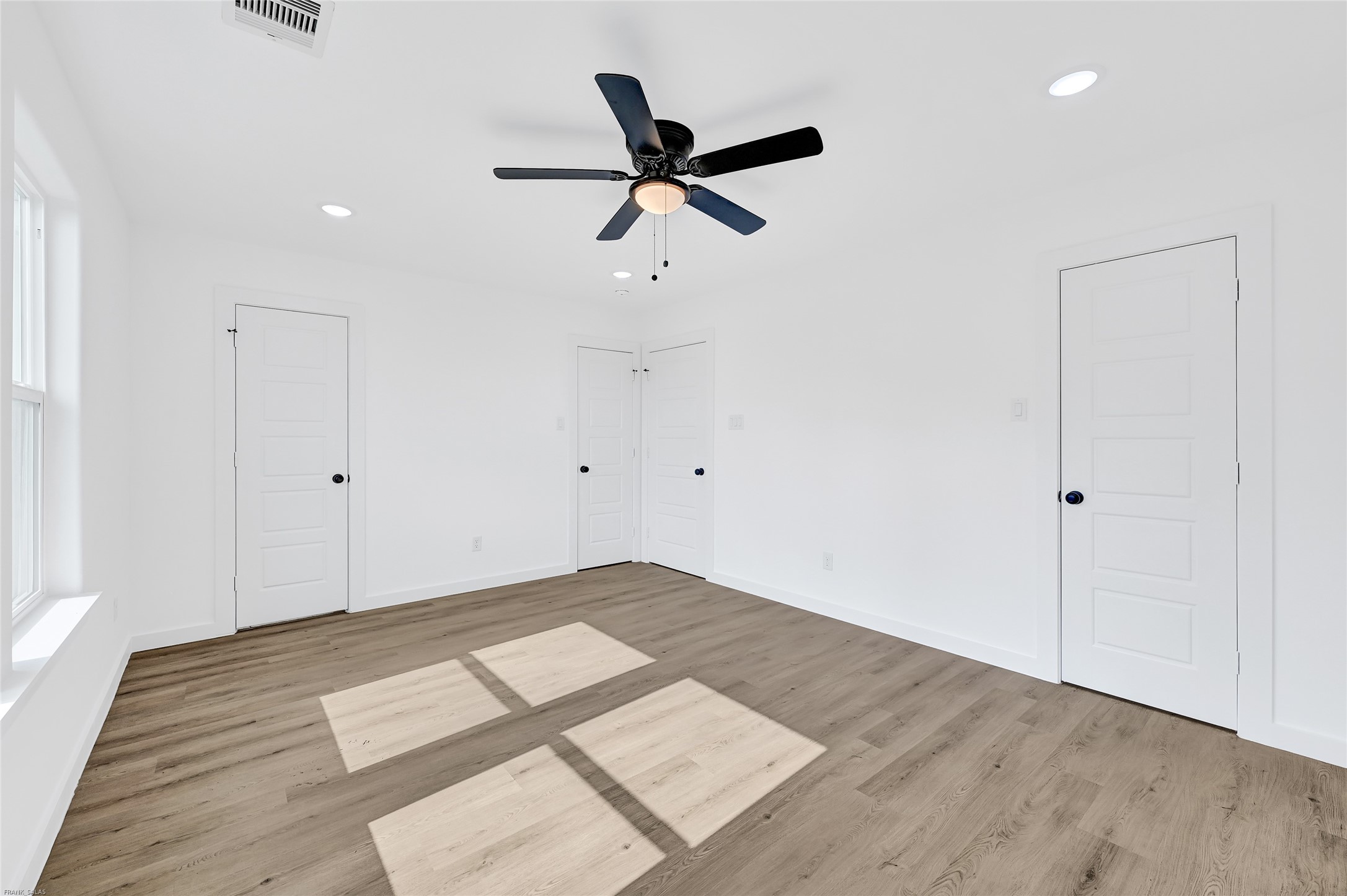 8023 Birmingham Street, Unit B Houston, TX 77028 - Photo 8 of 10 an empty room with wooden floor and windows