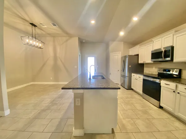 a kitchen with a sink a counter top space cabinets and stainless steel appliances