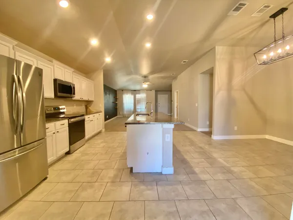 a kitchen with stainless steel appliances granite countertop a refrigerator and a stove