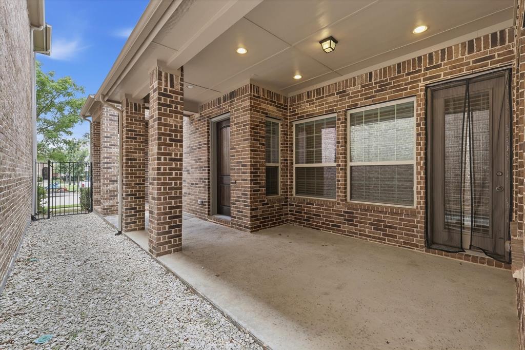 768 Huntingdon Street Coppell, TX 75019 - Photo 36 of 37 Private covered patio tucked between brick walls, offering a low-maintenance outdoor retreat with room for seating, plants, or a cozy bistro setup.