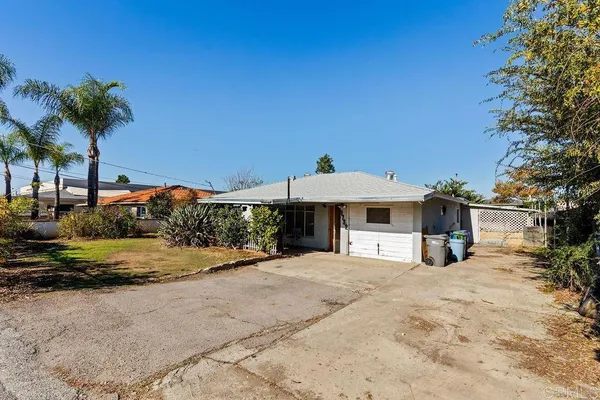 a view of a house with backyard and trees