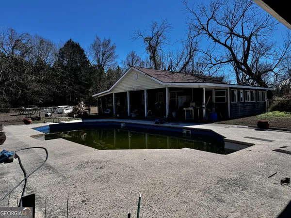 a view of a house with swimming pool and sitting area