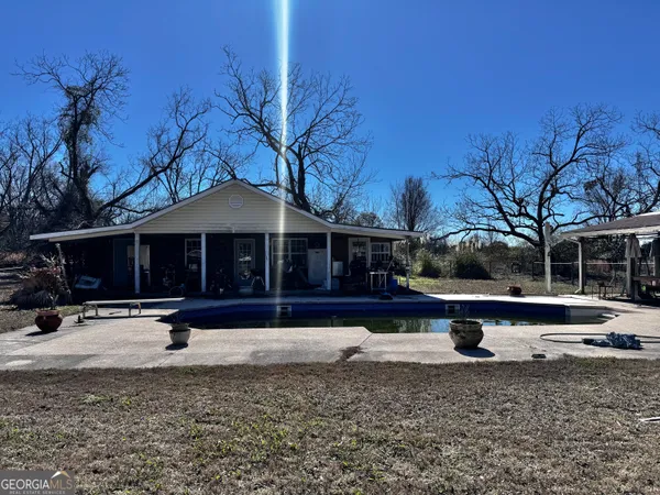 a front view of a house with a yard covered with snow in the background