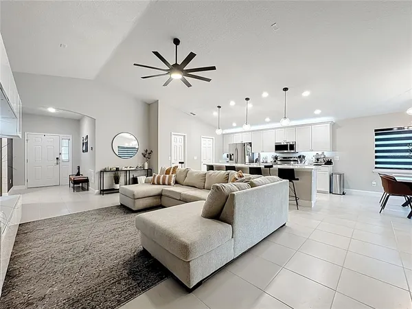 a living room with furniture and view of kitchen