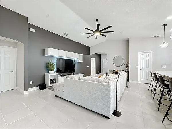 a living room with furniture a flat screen tv and a window