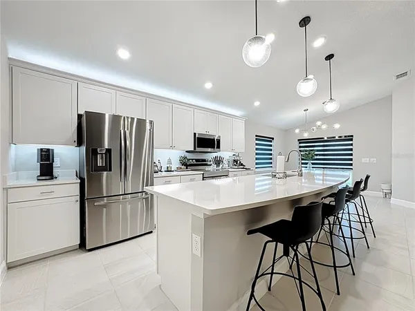 a kitchen with stainless steel appliances kitchen island a refrigerator and a stove