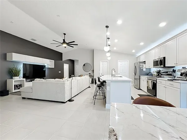 a living room with furniture and kitchen view
