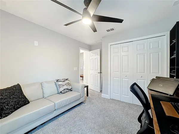 a living room with furniture and a ceiling fan