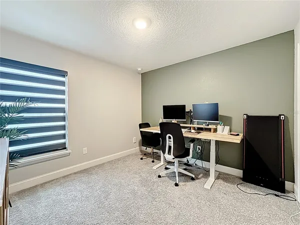 a view of a workspace with furniture and a window