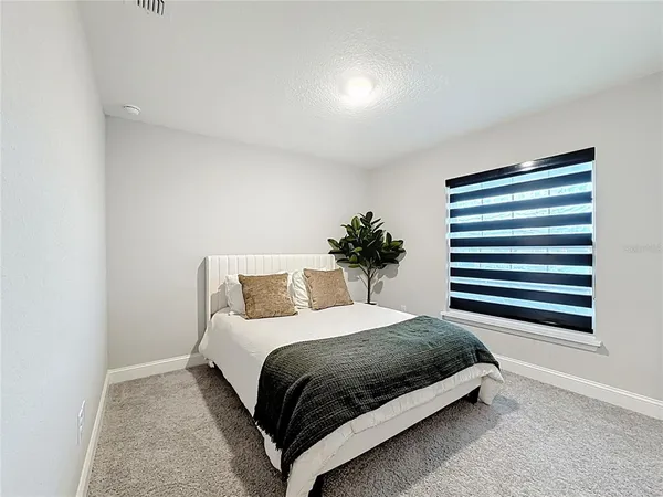 a bedroom with a bed and a painting on the wall