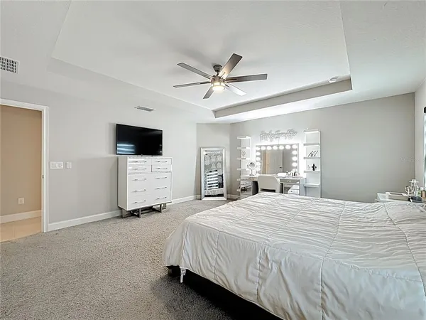 a spacious bedroom with a bed and a flat screen tv