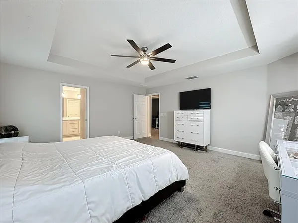 a bedroom with a bed a flat screen tv and a couch