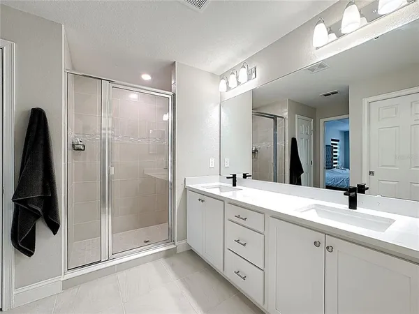 a bathroom with a double vanity sink a mirror and shower