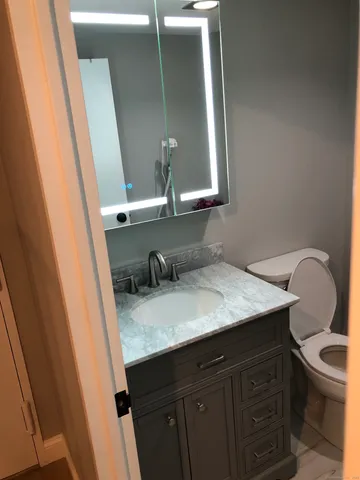a bathroom with a granite countertop sink and a mirror