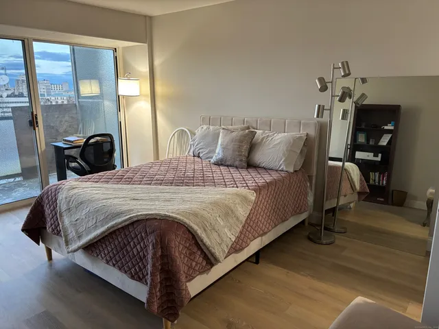 a large bed sitting in a bedroom next to a lamp with a dresser and chair