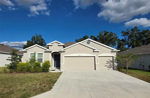 a front view of a house with a yard and garage