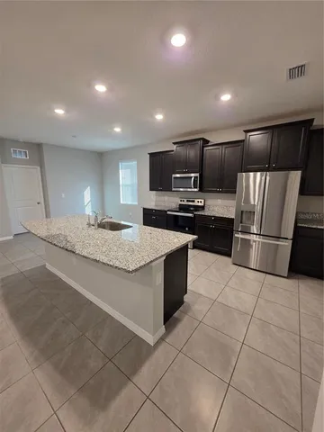a view of a big room with kitchen and chandelier