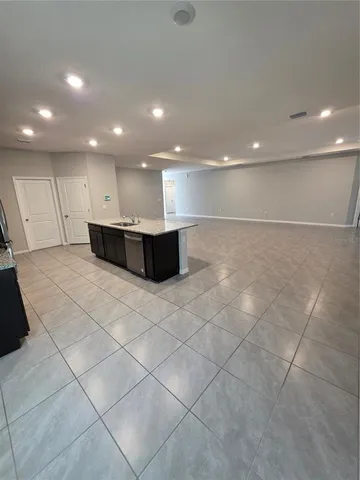 a large white kitchen with a large window and stainless steel appliances