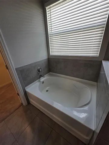 a bathroom with a tub a sink and a vanity