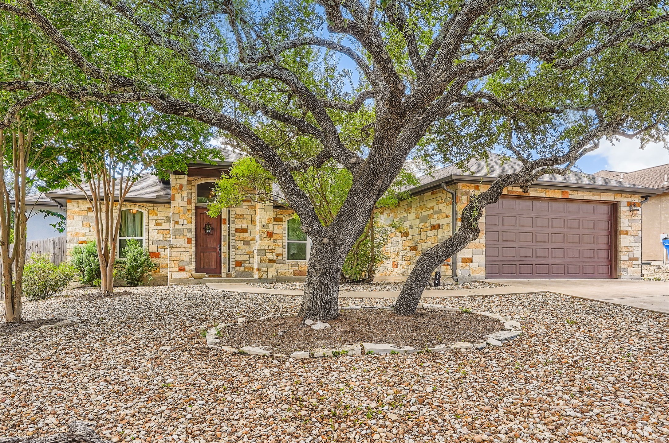 a front view of a house with a tree