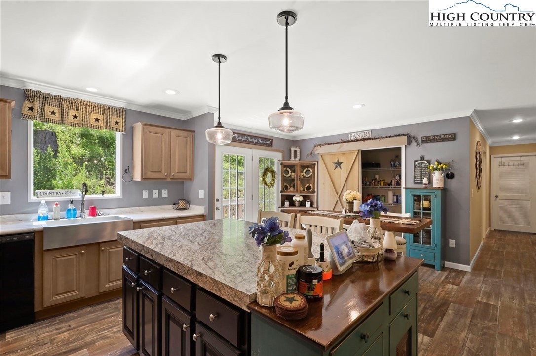 565 Valley Road Spruce Pine, NC 28777 - Photo 17 of 39 a view of a kitchen with kitchen island granite countertop a sink and a wooden floor