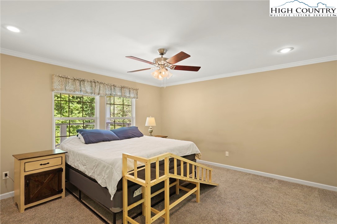 565 Valley Road Spruce Pine, NC 28777 - Photo 20 of 39 a bedroom with a bed and a ceiling fan