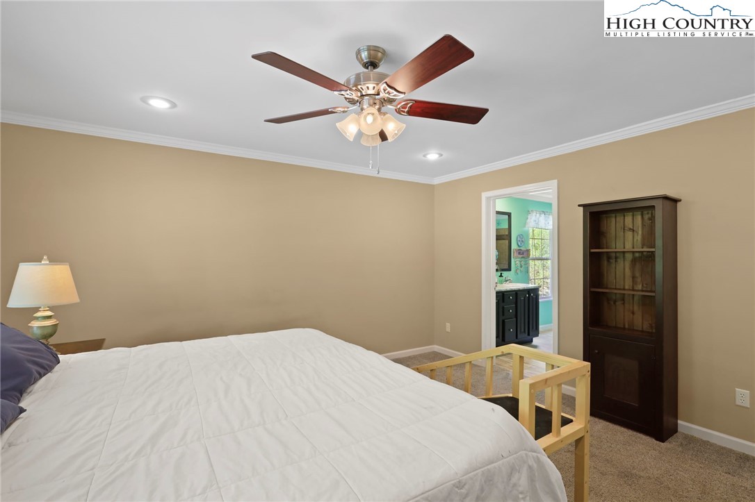 565 Valley Road Spruce Pine, NC 28777 - Photo 21 of 39 a bedroom with a bed and a chandelier