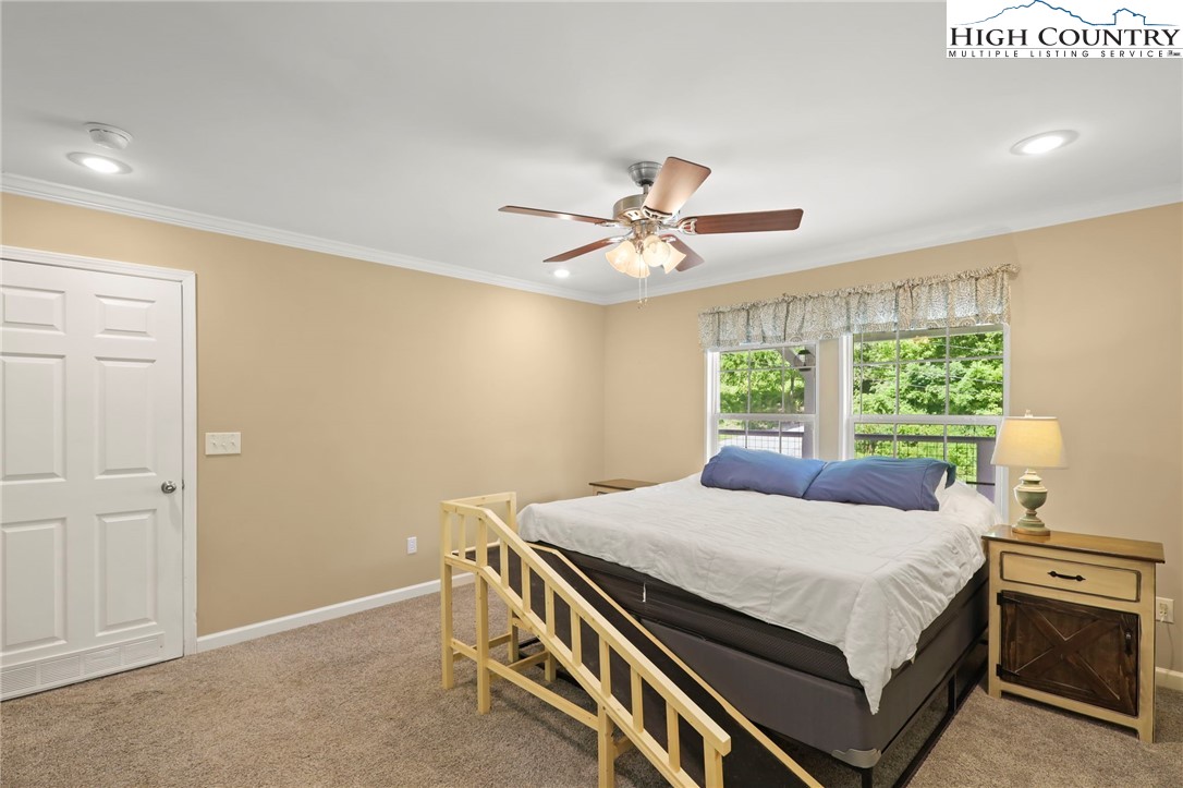 565 Valley Road Spruce Pine, NC 28777 - Photo 22 of 39 a bedroom with a bed and a chandelier