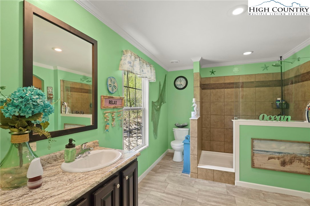 565 Valley Road Spruce Pine, NC 28777 - Photo 23 of 39 a bathroom with a granite countertop sink and a mirror